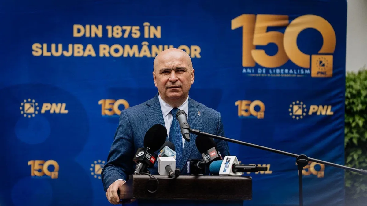 Ilie Bolojan la un pupitru cu microfoane, în fața unui panou al PNL cu inscripția „150 ani de liberalism”.