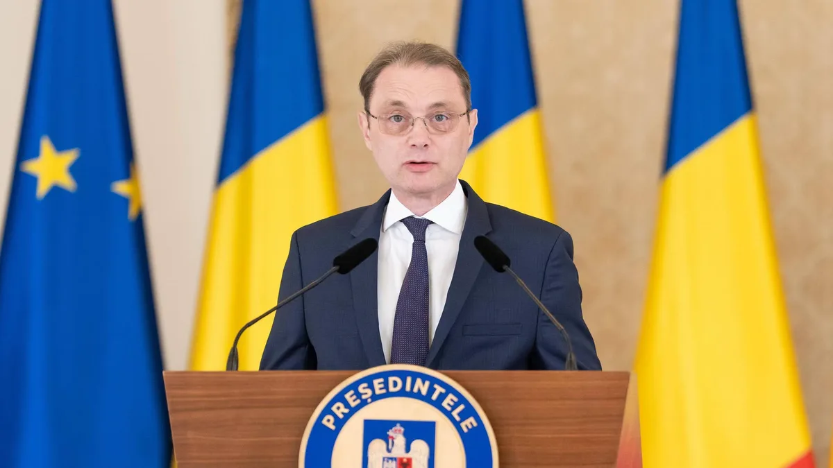 Luca Niculescu la un pupitru prezidențial, între drapelele României și Uniunii Europene.