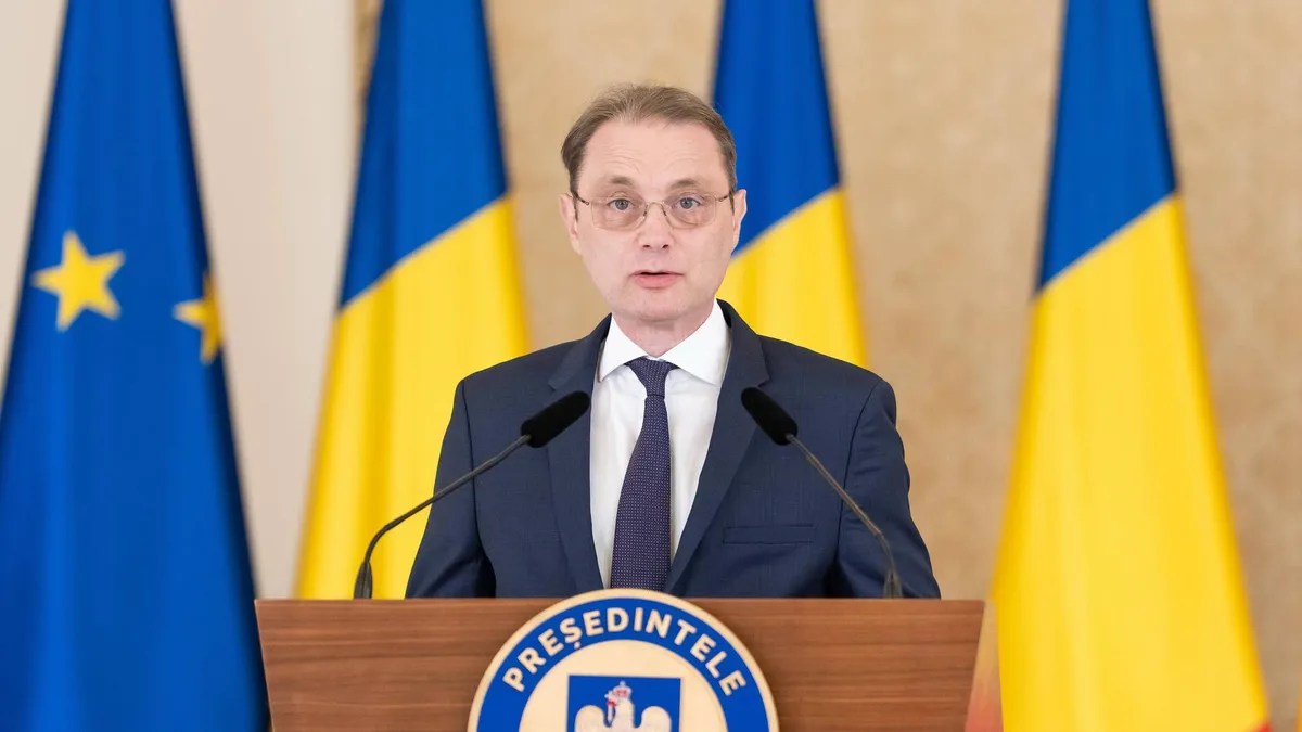 Luca Niculescu la un pupitru cu însemnele Președintelui României, în fața drapelelor României și Uniunii Europene.