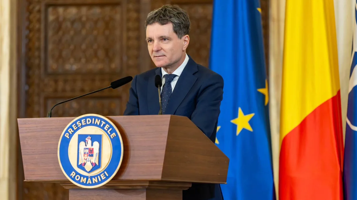 Nicușor Dan la pupitrul prezidențial, cu drapelele Uniunii Europene și României în fundal.