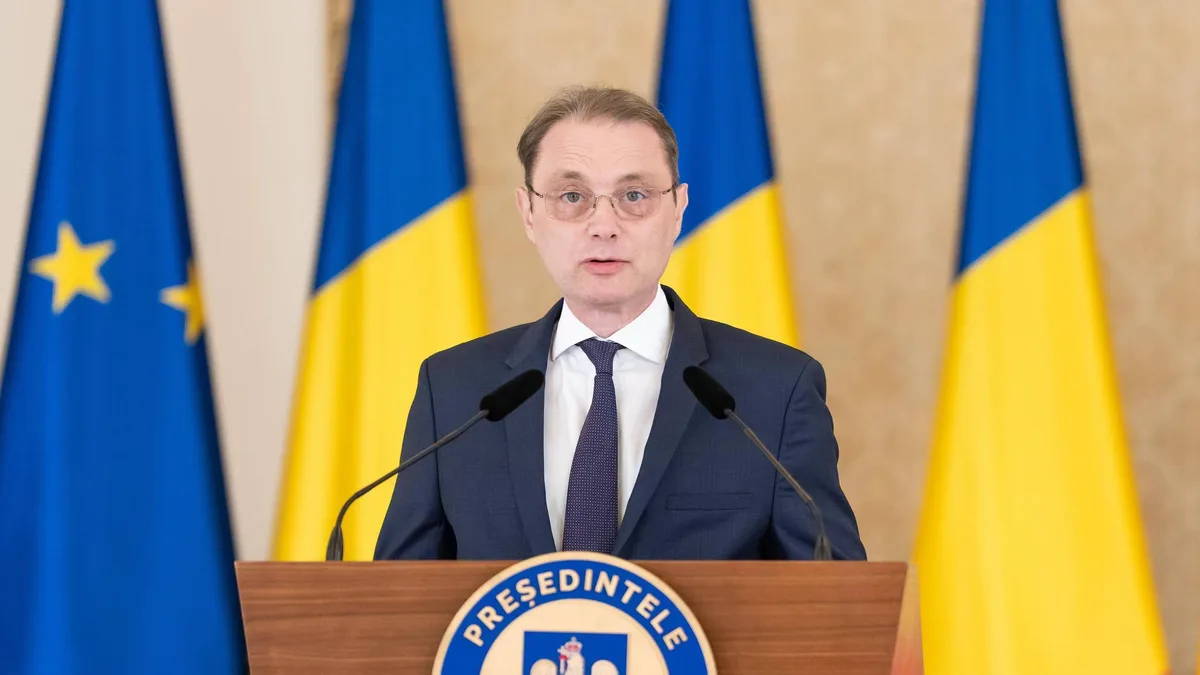 Luca Niculescu vorbește la un pupitru cu însemne prezidențiale, în fața drapelelor României și Uniunii Europene.