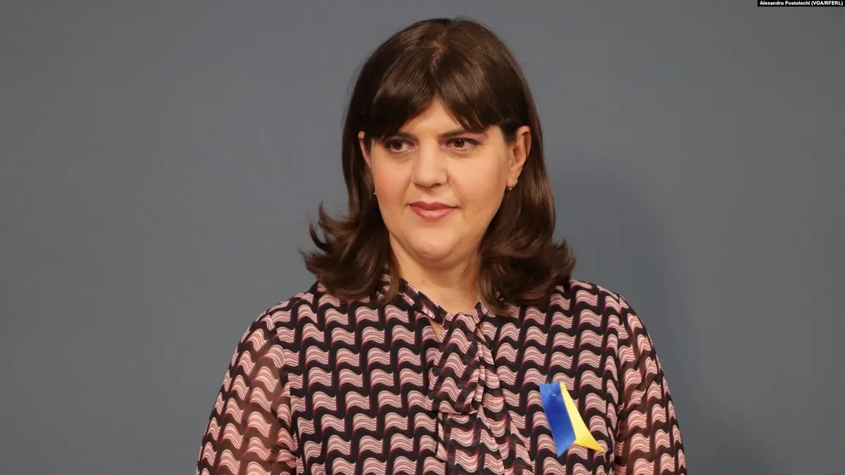 Laura Codruța Kövesi, cu o panglică albastră și galbenă la piept, pe un fundal gri.